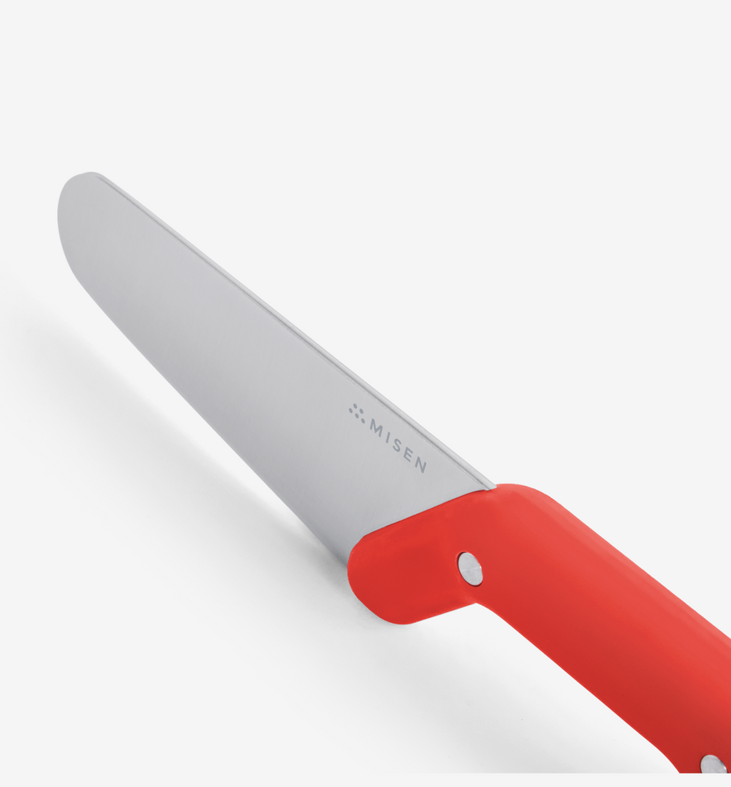 Misen kitchen knife with red handle, stainless steel blade close-up